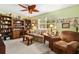Sunlit living room with comfortable seating, ceiling fan, and window views at 1214 Loch Rannoch Ct, Leesburg, FL 34788