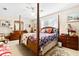 Large main bedroom suite with four-poster bed, soft carpet and window with blinds at 1214 Loch Rannoch Ct, Leesburg, FL 34788