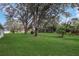 Spacious backyard with lush green lawn and mature trees, perfect for outdoor activities at 21502 King Henry Ave, Leesburg, FL 34748