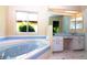 Relaxing bathroom with a large soaking tub, a vanity, and natural light from a window at 21502 King Henry Ave, Leesburg, FL 34748