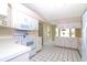 Bright kitchen with white cabinets, appliances, and black and white tiled floors at 21502 King Henry Ave, Leesburg, FL 34748