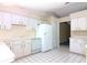 Bright kitchen features white cabinets, a dishwasher, and a refrigerator, with tile flooring at 21502 King Henry Ave, Leesburg, FL 34748