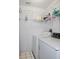 Small laundry room with stacked shelving above white washer and dryer at 21502 King Henry Ave, Leesburg, FL 34748