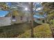 The backyard features a lawn, perimeter fence, sliding glass door, and a mature shade tree at 2354 Valhalla Dr, Tavares, FL 32778