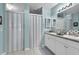 Bathroom showcasing double sinks, white cabinetry, and an enclosed shower and toilet at 2354 Valhalla Dr, Tavares, FL 32778