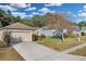 Charming single-story home with a well-manicured front yard, a two-car garage, and mature trees for shade at 2354 Valhalla Dr, Tavares, FL 32778