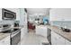 This bright kitchen features stone countertops, white cabinets, and a view of the living room at 2354 Valhalla Dr, Tavares, FL 32778