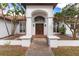 Grand entrance with double wood doors, arched entryway, and elegant landscaping creates inviting curb appeal at 38230 Yale Cir, Leesburg, FL 34788