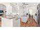 Bright kitchen featuring white cabinetry, an island with granite countertops and stainless steel appliances at 38230 Yale Cir, Leesburg, FL 34788