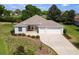 Aerial front view of home with manicured lawn, mature landscaping, and two-car garage at 5009 Harbor Hts, Lady Lake, FL 32159