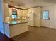 Bright kitchen with granite countertops, a window, and access to the back door at 558 Saint Andrews Blvd, The Villages, FL 32159