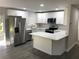 Modern kitchen with stainless steel appliances, sleek white cabinetry, and a stylish central island at 11 The Crescent, Minneola, FL 34715