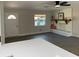 Open-concept living area boasts modern gray flooring and a built-in bench with floating shelf at 11 The Crescent, Minneola, FL 34715