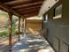 Enjoy outdoor living on this covered patio with seating area and a view of the backyard at 11 The Crescent, Minneola, FL 34715