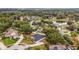 An aerial view of a home nestled in a lush, green neighborhood near a pond and mature trees at 14701 Timucua Pl, Clermont, FL 34711
