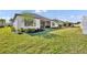 Well-maintained backyard with lush grass, landscaping, and a view of the home's exterior at 955 Ladera Ranch Rd, Kissimmee, FL 34759
