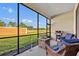 Screened lanai featuring comfortable seating, a fire pit, and views of the beautiful backyard and nature at 955 Ladera Ranch Rd, Kissimmee, FL 34759