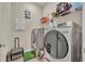 Well-equipped laundry room with modern washer and dryer, overhead shelving, and ample space for convenience at 955 Ladera Ranch Rd, Kissimmee, FL 34759