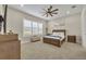 A relaxing primary bedroom features a neutral color palette, large window, and plush carpet at 955 Ladera Ranch Rd, Kissimmee, FL 34759