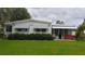 Inviting single-story home featuring a well-manicured lawn, shaded awnings, and a screened patio for relaxed outdoor living at 103 Fountain Cv, Leesburg, FL 34748