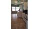 Functional kitchen with white cabinetry, a ceiling fan, laminate floors, and ample counter space, ready for culinary creations at 103 Fountain Cv, Leesburg, FL 34748