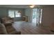Bright living room with wood floors and a view of the sunroom through french doors at 103 Fountain Cv, Leesburg, FL 34748