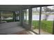 Sun room featuring large windows overlooking a picturesque lake, white walls and tile flooring at 103 Fountain Cv, Leesburg, FL 34748