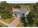 Aerial view of a charming single-story home with a brick driveway and lush greenery at 1063 Mesa Verde Ct, Clermont, FL 34711