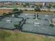 A beautiful aerial view of the well-maintained tennis courts in a lushly landscaped community at 1063 Mesa Verde Ct, Clermont, FL 34711