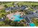 Aerial view of the community clubhouse and resort-style pool surrounded by lush landscaping and palm trees at 1063 Mesa Verde Ct, Clermont, FL 34711