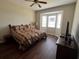 Comfortable bedroom featuring a large bed, wood flooring, and bay windows for natural light at 1063 Mesa Verde Ct, Clermont, FL 34711
