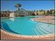 A large community pool surrounded by a brick deck and lounge chairs at 1063 Mesa Verde Ct, Clermont, FL 34711