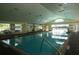 Well-lit indoor swimming pool with a high ceiling and tile flooring at 1063 Mesa Verde Ct, Clermont, FL 34711