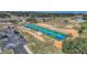 Overhead view of multiple pickleball courts with vibrant blue surfaces, surrounded by greenery and parking at 1063 Mesa Verde Ct, Clermont, FL 34711