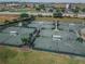 Aerial view of tennis courts, featuring shaded areas and surrounding landscaping, perfect for outdoor sports at 1063 Mesa Verde Ct, Clermont, FL 34711