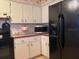 Bright kitchen features white cabinets, stainless steel microwave, and a black refrigerator at 1344 Cr 437, Lake Panasoffkee, FL 33538