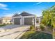 Charming single-story home showcasing a two-car garage, inviting walkway, manicured landscaping at 1658 Galloway Dr, The Villages, FL 32163