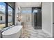 Elegant bathroom showcasing a soaking tub, glass-enclosed shower, and stylish fixtures at 16914 Vinci Way, Bella Collina, FL 34756