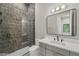 Modern bathroom featuring a tiled shower with glass door and vanity with white countertop at 16914 Vinci Way, Bella Collina, FL 34756