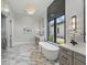 Serene bathroom featuring a standalone tub, marble flooring, and elegant lighting fixtures at 16914 Vinci Way, Bella Collina, FL 34756