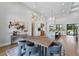 Elegant dining area open to the kitchen, featuring a modern chandelier and contemporary decor at 16914 Vinci Way, Bella Collina, FL 34756