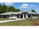 Elegant single-story home with a gray roof, stone accents, and a well-manicured lawn on a sunny day at 16914 Vinci Way, Bella Collina, FL 34756