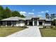 Beautiful gray one-story home featuring an extended driveway and manicured landscaping with blue skies overhead at 16914 Vinci Way, Bella Collina, FL 34756
