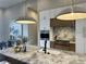 Stylish kitchen featuring a marble island, modern lighting, and stainless steel appliances at 16914 Vinci Way, Bella Collina, FL 34756