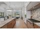 Modern kitchen with custom cabinets, marble countertops, professional-grade appliances, and an open layout at 16914 Vinci Way, Bella Collina, FL 34756