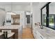 Well-lit kitchen featuring marble counters, white cabinets, stainless steel appliances, and hardwood floors at 16914 Vinci Way, Bella Collina, FL 34756