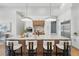 Up-close kitchen featuring marble island with seating, stainless appliances, custom cabinetry and pendant lights at 16914 Vinci Way, Bella Collina, FL 34756