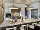 Modern kitchen featuring a large island with marble countertop, stainless steel appliances, and sleek white cabinetry at 16914 Vinci Way, Bella Collina, FL 34756