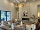 Bright, modern living room featuring a fireplace, contemporary lighting, and an expansive gray sectional sofa at 16914 Vinci Way, Bella Collina, FL 34756