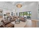 Spacious living room with a large sectional sofa, modern lighting, and sliding glass doors leading to the backyard pool at 16914 Vinci Way, Bella Collina, FL 34756